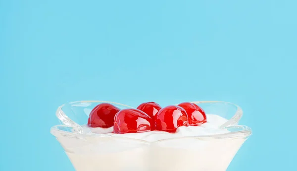 Un postre con cereza al maraschino en una copa. Crema batida, yogur griego, helado. De cerca. — Foto de Stock