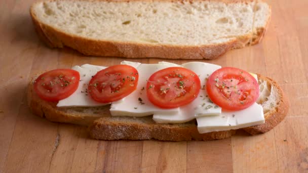 Servire un brindisi dal pane fatto in casa con pomodoro e formaggio fresco. Versare l'olio d'oliva sul panino. Cibo vegetariano sano — Video Stock