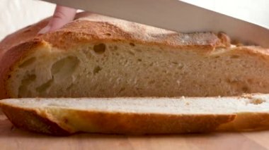 Bir kadın taze ev yapımı ekmek kesti. Sağlıklı beslenme