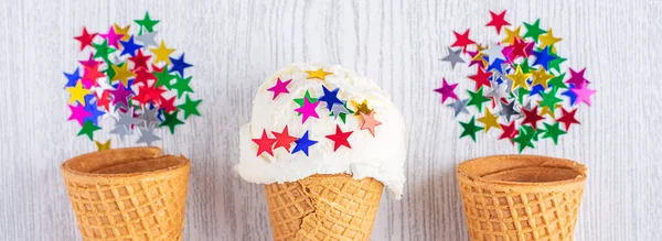 Conos de helado decorados con estrellas sobre un fondo de madera blanca. Un cono de helado al estilo oblea. Hora de verano. Banner largo — Foto de Stock