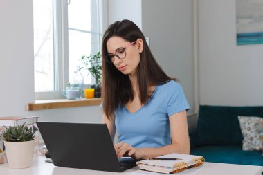 Modern dizüstü bilgisayarda çalışan çekici melez kadın evde bilgisayar kullanan serbest çalışan. Uzak iş çevrimiçi öğrenme kavramı