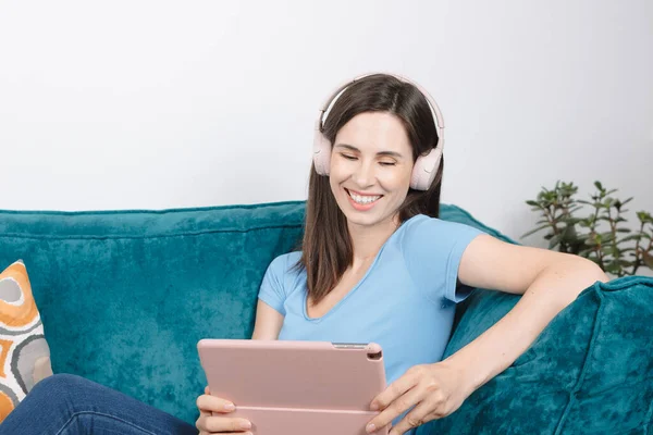 Portrait beautiful brunette millennial young woman using tablet social media app wearing headphones,laughing — Stock Photo, Image