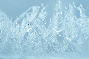 Kapalı kış penceresi parlak, buzlu desenlerle kaplı. Yılbaşı makro görünümü arkaplanı.