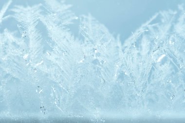 Kapalı kış penceresi parlak, buzlu desenlerle kaplı. Yılbaşı makro görünümü arkaplanı.