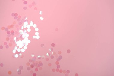 Holografik yuvarlak konfetiyle birlikte gül rengi pastel renkli şenlik arka planı. Metin ve tasarım için kopyalama alanı olan düz konum biçimi.