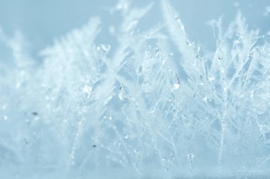 Kapalı kış penceresi parlak, buzlu desenlerle kaplı. Yılbaşı makro görünümü arkaplanı.