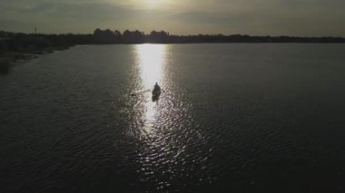 Buenos Aires 'te bir teknede bir insanla birlikte bir göle güneş yansıması.