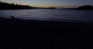 Bariloche 'deki Nahuel Huapi gölünün kıyısından başlayan hava manzarası. Dağlar ve kışın soğuk günbatımı olan küçük bir ada..