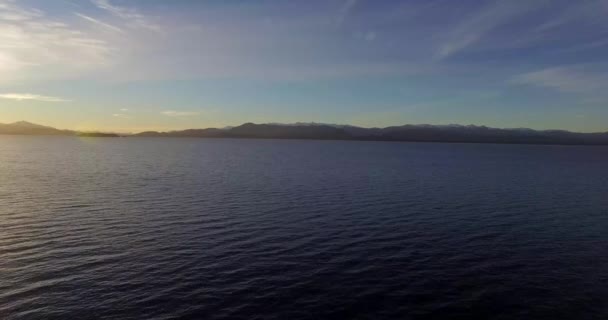 バリローチェのNahuel Huapi湖の空の景色と山と小さな島冬と冷たい夕日の後ろ — ストック動画