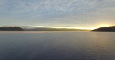 Bariloche 'deki Nahuel Huapi gölünün kıyısından başlayan hava manzarası. Dağlar ve kışın soğuk günbatımı olan küçük bir ada..