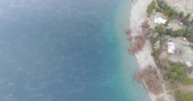 Nahuel Huapi Gölü kıyısında. Etrafı evlerle çevrili saydam su..