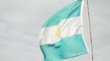 Bulutlu bir vadide yanan bir Arjantin bayrağı.