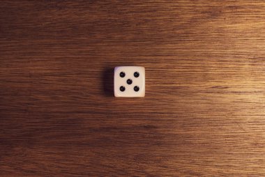 Tahta bir masanın üzerinde beş numaralı zar.