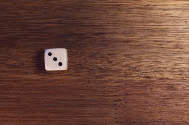 Tahta bir masanın üzerinde üç numaralı zarlar.