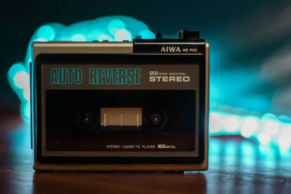 Ve eski, antika ve antika walkman. Arkasında parlak ışıklar olan bir ahşap masanın üzerinde..