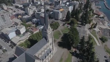 Merkezin yakınındaki Bariloche katedralinin hava manzarası şehrin işlek bir yerinde ağaçlar ve otlarla çevrili.
