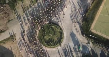 Buenos Aires 'te bir maratonda koşan bir sürü koşucu, Vicente Lopez Arjantin' de güneşli bir yaz gününde şehrin ortasında bir kavşağın yanından geçiyor.