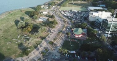 Birçok koşucu Buenos Aires şehrinde bir maratonda koşuyor, güneşli bir yaz gününde şehrin ortasındaki bir sokaktan geçiyor Arjantin 'in Vicente Lopez bölgesinde nehir ve çevresi doğa ile çevrili..