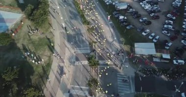 Birçok koşucu Buenos Aires şehrinde bir maratonda koşuyor, güneşli bir yaz gününde şehrin ortasındaki bir sokaktan geçiyor Arjantin 'in Vicente Lopez bölgesinde nehir ve çevresi doğa ile çevrili..