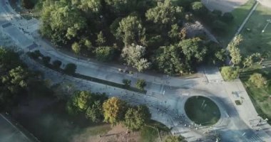 Buenos Aires 'te bir maratonda koşan bir sürü koşucu, Vicente Lopez Arjantin' de güneşli bir yaz gününde şehrin ortasında bir kavşağın yanından geçiyor.