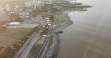 Birçok koşucu, Puerto Madero Arjantin 'in güneşli bir yaz gününde, Buenos Aires' te bir maratonda, şehrin ortasındaki bir sokaktan geçerek nehrin kenarındaki parklarla birlikte koşuyor.