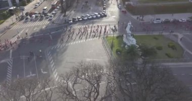Birçok koşucu, Puerto Madero Arjantin 'in güneşli bir yaz gününde, Buenos Aires' te bir maratonda, şehrin ortasındaki bir sokaktan geçerek nehrin kenarındaki parklarla birlikte koşuyor.