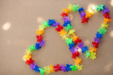 Kontrplak arka planda iki parlak gökkuşağı kalbi.