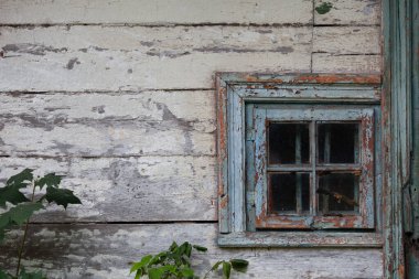 Klasik pencereli çok eski ahşap evin beyaz duvarı. Mavi ahşap pencere, soyulmuş boya, çatlaklar ve çizikler..