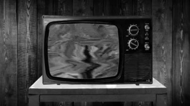 Zoom daha sonra 70 'lerin eski bir televizyon setine sabit çekim yaptı. Cızırtı, gürültü, tahıl, kötü resepsiyon televizyonu.