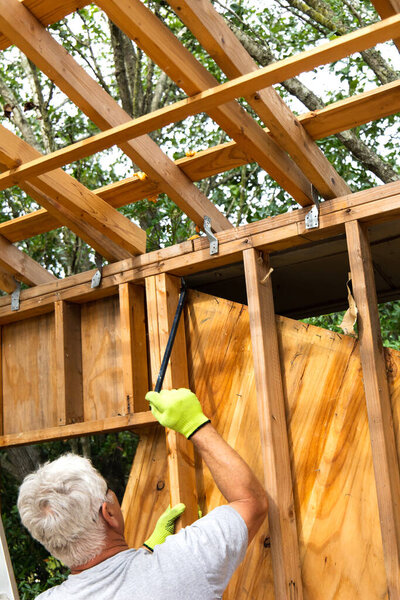 Demolition phase with a man tearing down an old shed in a backyard that was rotting and falling apart