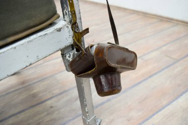 Eski film kamerası kemer çantasında, deri çantada, eski metal yatakta asılı.