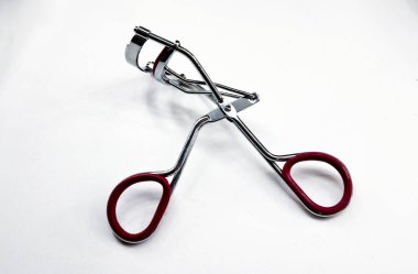 Paslanmaz çelik kirpik bigudisi beyaz arkaplanda izole edilmiş.