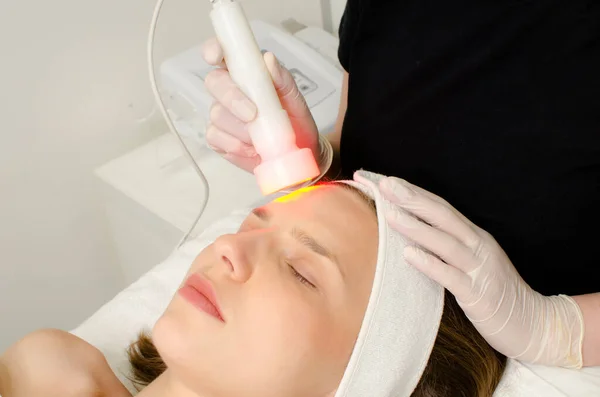 Kosmetikerin Die Rotlichttherapie Für Weibliche Kunden Schönheitssalon Gesichtsfototherapie Zur Reinigung — Stockfoto