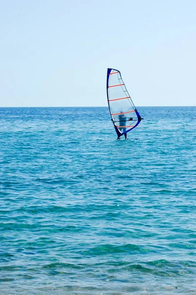 Jeden Muž Malé Plachetnici Otevřeném Moři Těší Windsurfing Vertikální Obrázek — Stock fotografie