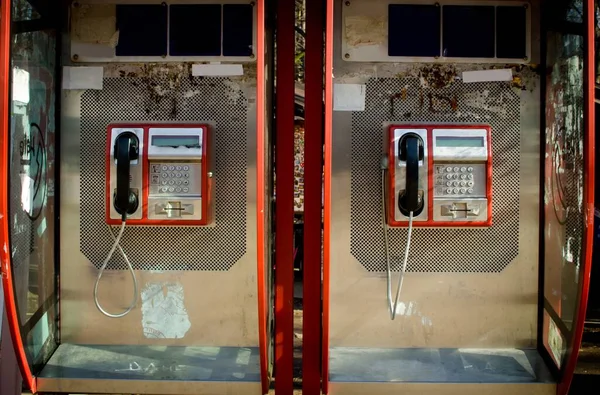 两个复古的红色电话亭关闭 隔离在20世纪阳光灿烂的日子技术 — 图库照片