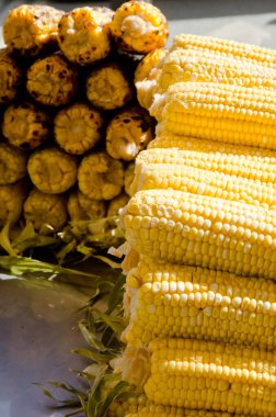 Güneşli bir günde, sokak satışında ızgara ve haşlanmış mısırın aşırı yakın çekimi.