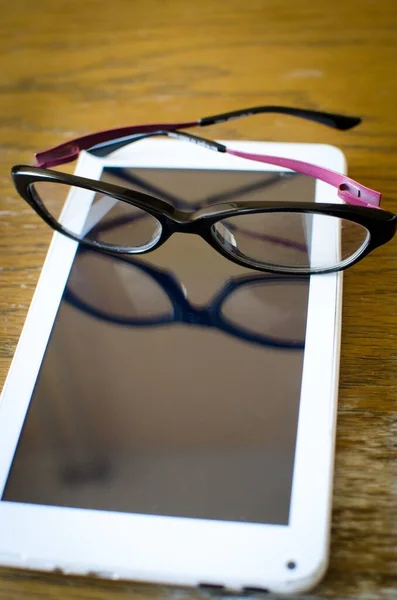 Schwarze Brille Auf Weißem Tablet Mit Reflexion Auf Holztisch Innenraum — Stockfoto