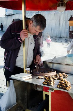 İstanbul, Türkiye, 07 Mart 2019: Eminonu, Istanbu 'da Mısır Çarşısı' nın önünde kestane satan geleneksel sokak arabası satıcısı