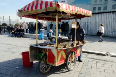 İstanbul, Türkiye, 07 Mart 2019: Güneşli bir günde Eminonu, İstanbul 'da Mısır Çarşısı önünde kavrulmuş kestane ile geleneksel sokak arabası satışı