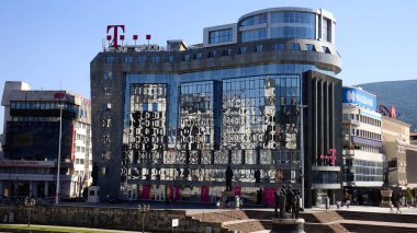 Üsküp, Kuzey Makedonya, 27 Haziran 2019: kent merkezinin güneşli yaz gününde Üsküp 'teki büyük çağdaş Telekom binasının camlarına yansıması