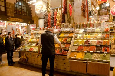İstanbul, Türkiye, 07 Mart 2019: Mısır Çarşısı, İstanbul 'da çeşitli renklerde baharat tozu ve bitkilerle market önünde duran pazar satıcısı