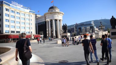 Üsküp, Kuzey Makedonya, 27 Haziran 2019: Üsküp 'ün başkenti Kuzey Makedonya' nın ana meydanı, modern mimarisi ve tarihi binalarındaki insanlar güneşli yaz gününde 