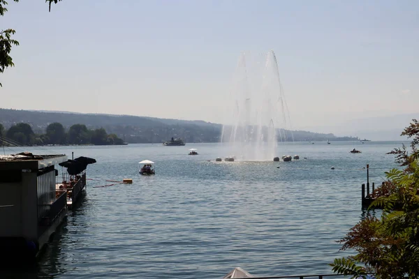 Zürih, İsviçre, 23 Temmuz 2019: Güneşli bir günde Zürih Gölü 'nde çeşme 