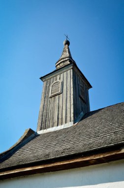 Mavi gökyüzünde haçı olan eski kilisenin ahşap kulesi