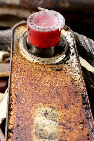 old rusty oil can with red lid close up