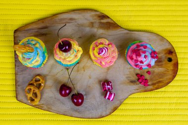 Ahşap tahtada kremalı renkli kekler..