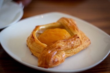 Beyaz tabakta şeftalili çörek..