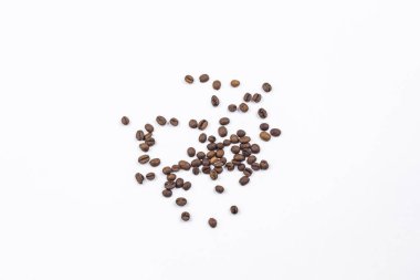 Kahve çekirdekleri beyaz arka plana saçılmış..