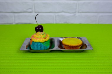 İki kek, biri madalyalı, demir tezgahta..