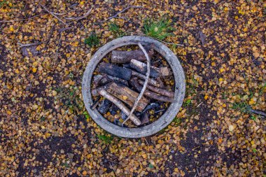 Sonbahar ormanındaki açıklıkta şöminesi olan kamp şöminesi..